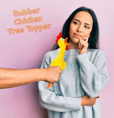 a woman holding a rubber chicken toy in front of her face with the words rubber chicken tree topper