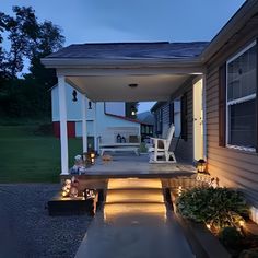 an outdoor patio with steps lit up at night, leading to the front door and back porch