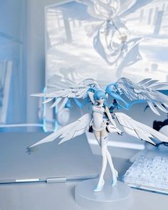 a white and blue figurine sitting on top of a desk