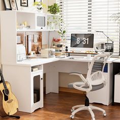 a desk with a guitar and computer on it