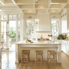 a kitchen with two stools and an island in front of the stove top oven