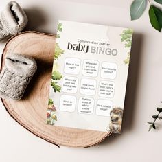 a baby book sitting on top of a wooden plate next to two slippers and a plant