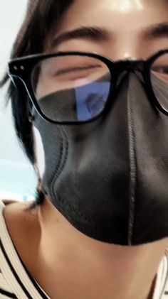 a person wearing glasses and a black mask