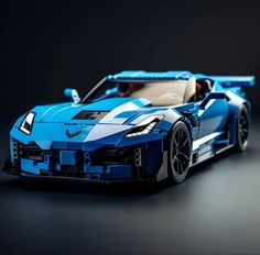 a lego model of a blue sports car on a black surface with the hood down