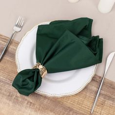 a place setting with green napkins and silverware