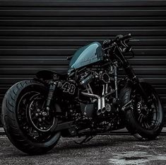 a black motorcycle parked in front of a garage door