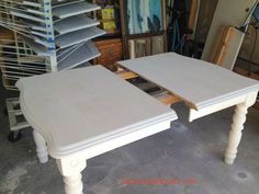 two white tables sitting next to each other in a room filled with shelves and drawers