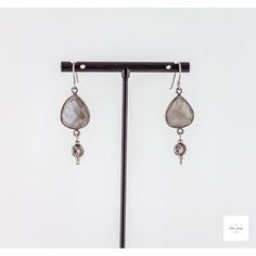 These Grey Moonstone Earrings from Miel Jewelry Shop are so unique and pretty. The faceted, shimmery grey moonstone is set in a black gold-plated bezel and is complemented by fancy black gold-plated beads. Niobium hooks and wire complete the look. These earrings measure 1.8 inches in length. These earrings are perfect for a night out on the town or a special event. They will add a touch of elegance and sophistication to any look. Labradorite Dangle Earrings For Pierced Ears, Teardrop Labradorite Earrings, Silver Teardrop Chandelier Earrings With Natural Stones, Elegant Dangle Teardrop Earrings With Natural Stones, Elegant Natural Stone Dangle Teardrop Earrings, Silver Dangle Moonstone Crystal Earrings, Silver Moonstone Dangle Crystal Earrings, Elegant Linear Drop Earrings With Natural Stones, Elegant Drop Earrings With Natural Stones