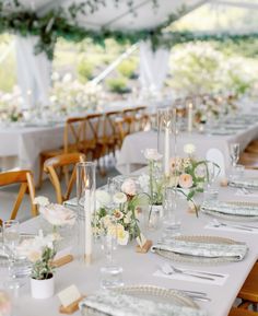 the tables are set with white linens and floral centerpieces