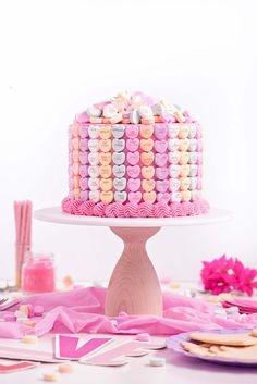 a heart shaped cake with pink icing and hearts on top