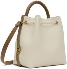 LWG-certified grained calfskin shoulder bag in beige and taupe. · Hand-wrapped carry handle · Adjustable crossbody strap · Logo stamp at face · Logo hardware at sides · Drawstring closure · Buffed lambskin lining · H9 x W11 x D6 Supplier color: Misty ivory Beige Calf Leather Bag With Adjustable Strap, Beige Calf Leather Shoulder Bag With Handle Drop, Beige Calf Leather Bag With Handle Drop, Cream Calf Leather Shoulder Bag With Gold-tone Hardware, Beige Calf Leather Shoulder Bag With Detachable Strap, Beige Calf Leather Crossbody Satchel, Cream Leather Bucket Bag With Top Handle, Cream Leather Bucket Bag With Top Carry Handle, Beige Calf Leather Bag With Dust Bag