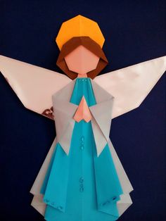 an origami angel with blue dress and yellow hat on it's head