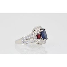 This is part of Chairish’s Fine Jewelry assortment.  Sapphire Ruby Diamond Ring 18K White Gold  This lovely Sapphire Ruby Diamond Ring is set in 14K White Gold. It features a Oval cut Sapphire weighing in at 2.67 Carats, flanked by 2 Rubys square cut and weighing 0.70 carats and White Diamonds, F-G, VS weighting in at 2.50 Carats. Set in a square shank mounting, measuring approximately 15mm tapering to 2.4mm Size 6.5. Total weight: 5.87 carats. I purchased this to go with many of my Tutti Frutti Classic Multi-stone Diamond Rings, Classic Multi-stone Sapphire Ring With Diamonds, Luxury Asscher Cut Ruby Ring, Luxury Asscher-cut Sapphire Ring With Diamond Details, Formal Asscher Cut Ruby Ring With Center Stone, Elegant Cushion Cut Gemstone With Center Stone, Elegant Cushion Cut Gemstones, Elegant Asscher Cut Birthstone Ring, Heirloom Asscher Cut Rings With Accent Stones