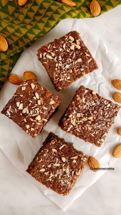 four squares of brownies with almonds on top