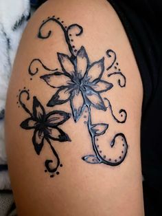 a woman's thigh with a tattoo design on the side of her leg and flowers in the middle