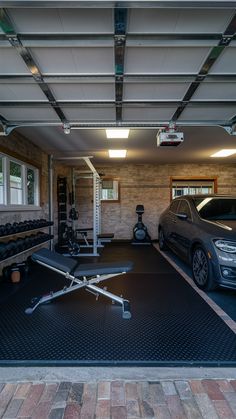 a car is parked in the garage next to a bench and exercise equipment on the floor