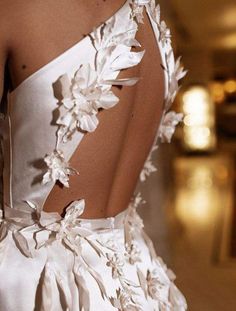 the back of a white dress with flowers on it