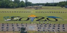 an aerial view of the olympic logo on a field with chairs in front of it