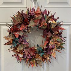 an origami wreath hanging on the front door