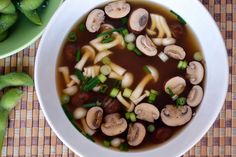 a bowl of soup with mushrooms and green onions