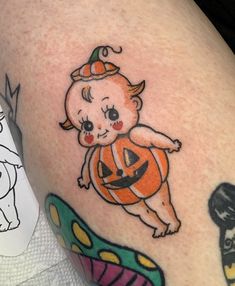 a small baby in a pumpkin costume on the arm