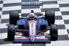 a man driving a racing car down a race track