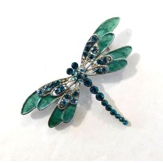 This Silver-Toned Dragonfly Brooch Pin Is Adorned With Gorgeous Green And Blue Crystals. It's A Versatile Piece, Perfect For Adding A Touch Of Sparkle To Any Ensemble. Silver-Toned Brooch Pin Features A Dragonfly Design Embellished With Green And Blue Crystals And Enamel Measures Approx. 2.75" Wide And 2" Tall Condition: New Thanks For Shopping At Lone Star Mercantile. Please Visit My Closet To See More. Dragonfly Brooch, Dragonfly Design, Dragonflies Design, Vintage Celluloid, Lone Star, Dragonflies, Vintage Rhinestone, Green And Blue, Blue Crystals