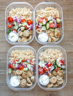 four plastic containers filled with food on top of a wooden table