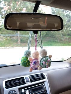 three crocheted ornaments hanging from the dash board of a car