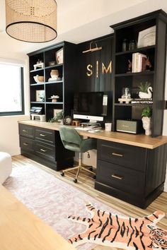 a home office with black cabinets and zebra rug