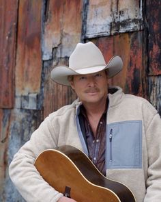 a man wearing a cowboy hat and holding a guitar