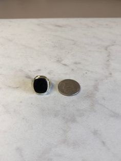 A Rare Beautiful and Classic 10kt Yellow Gold Unisex Onyx Ring consisting of a 12mm x 14mm Antique Cushion Shape Genuine Onyx Gemstone flat buff top bezel set in old style ring in finger size 4 1/4. This ring can be adjusted to any size. Excellent Condition. This item would Retail for $749.00 Classic Onyx Ring Jewelry, Classic Onyx Ring, Classic Adjustable Black Enamel Rings, Onyx Open Ring For Formal Occasions, Classic White Gold Onyx Rings, Formal Onyx Open Ring Jewelry, Classic Adjustable Jewelry With Black Enamel, Black Polished Round Band Rings, Classic Round Jewelry With Black Enamel