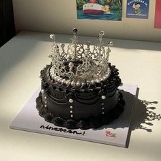 there is a black cake with pearls on it