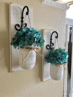 two mason jar wall hangings with flowers in them