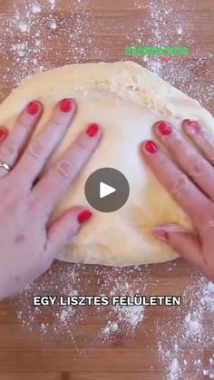 two hands kneading dough on top of a wooden table