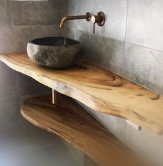 a bathroom sink made out of wood with a bowl on the counter and metal faucet