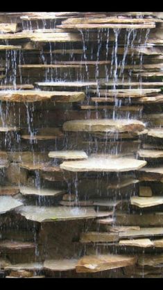 the water is running down the rocks and into the pool