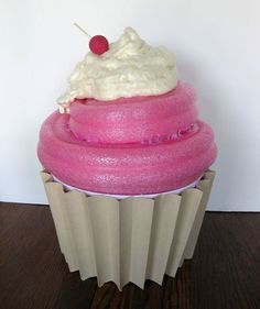 there is a pink cupcake with white frosting and a cherry on the top