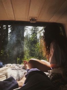 two people are sitting in the back of a truck with their feet up on the bed