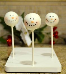 three snowman cake pops sitting on top of a counter