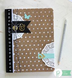 a brown and white dotted notebook next to a pen