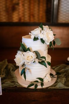 a wedding cake with white flowers and greenery