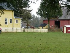 a red truck is parked in front of a yellow house with a white picket fence