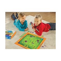 two children playing with a board game on the floor