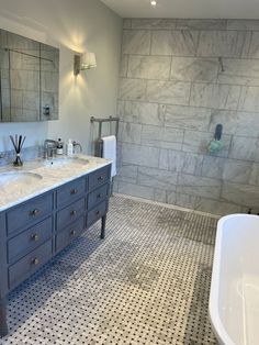 a large bathroom with two sinks and a bathtub in it's center area