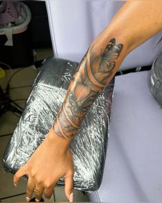 a woman with a tattoo on her arm and foot is sitting in a salon chair