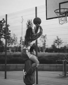 a man and woman are playing basketball on the court