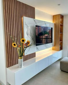 a vase with sunflowers in it sitting on a white entertainment center that is built into the wall