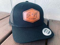 a black and orange trucker hat sitting on top of a wooden bench