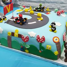 a birthday cake decorated with mario kart and cars